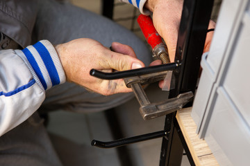 The hand of a master worker installing a shelf in a shop.