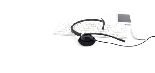 VOIP headset on laptop computer keyboard. Communication support for callcenter and customer service Helpdesk. Isolated on white background. top view flat lay background. Space for text design..