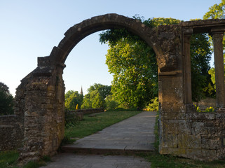View on a city garden through a ruined gate