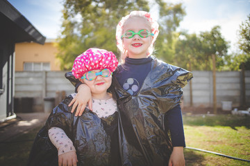 Close up image of two young girls, sisters, playing dress up during the Covid-19 pandemic and global lockdown of 2020