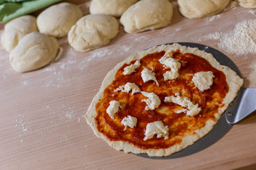 selbstgemachte Pizza Margherita, Tomatensauce und Mozzarella, Pizzateig im Hintergrund, Studio, Studio