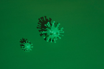 green volumetric models of coronavirus with a hard shadow in rows on a green background.