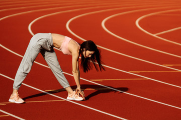 Fitness sport girl in fashion sportswear doing yoga fitness exercise on the stadium, outdoor sports