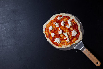 selbstgemachte Pizza Margherita, Tomatensauce und Mozzarella, auf einem Pizzaschieber, von oben, Studio