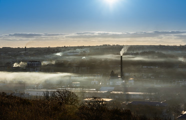 a city on the island of Sakhalin in Russia in the morning in the fog and smoke of factory pipes