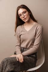 Photo of charming elegant woman looking at camera and sitting on chair