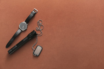 Naklejka premium Modern flashlight with tag and watch on color background