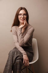 Photo of charming pleased woman smiling and sitting on chair