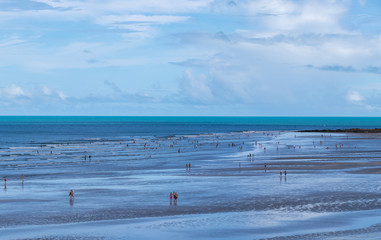 Fototapeta na wymiar Pessoas caminhando na praia em Jericoacoara.