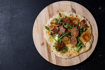 selbstgemachte Pizza mit Kräuterbutter, Mascarpone, Mozzarella, Rucola und Kartoffelchips, Studio