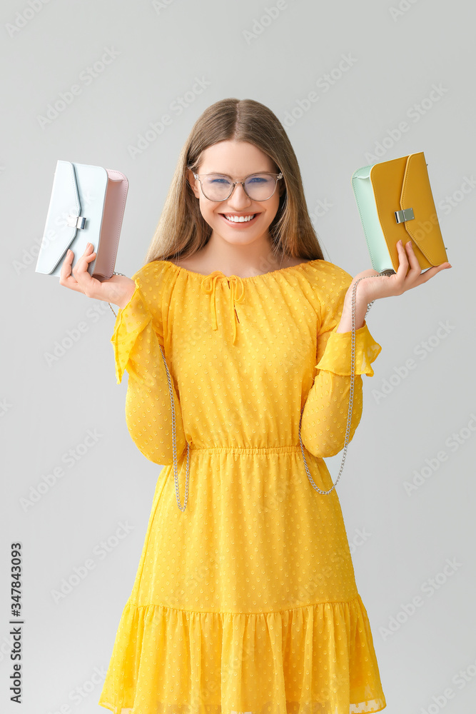 Wall mural Beautiful woman with stylish bag on grey background