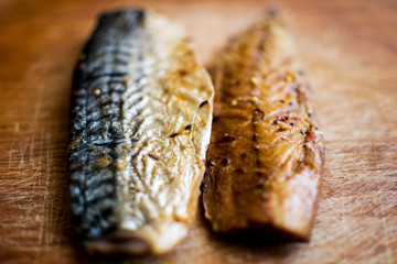 Smoked fish on a wooden plate. Kipper. Mackerel