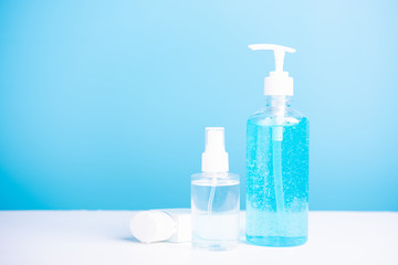 Plastic dispenser sanitizer alcohol gel pump and spray bottle for washing hand hygiene prevention of coronavirus virus studio shot on blue background