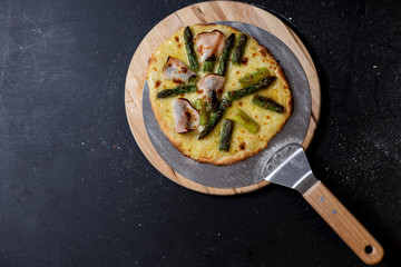 selbstgemachte Pizza mit Sauce Hollandaise, Mozzarella, grüner Spargel und Truthanschinken, Studio