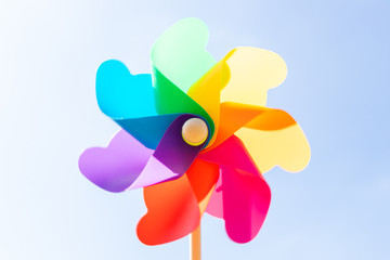 Colorful toy plastic turbine windmill on blue sky background
