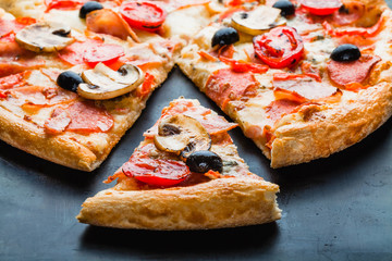 Pizza with mushrooms with a separate slice in the oven close-up. Pizza menu. Pizza delivery.