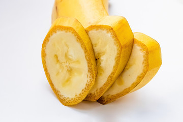 slices of a yellow banana in a cut on a white background macro shot