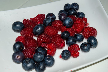 Blueberries And Raspberries Isolated on a white plate. White background.