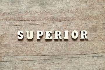 Letter block in word superior on wood background