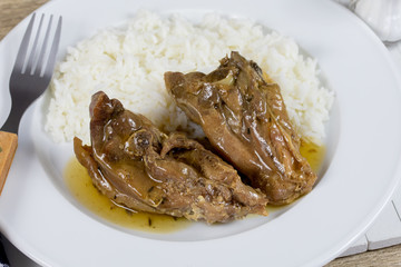 morceaux de coq cuisiné à la bière et riz dans une assiette