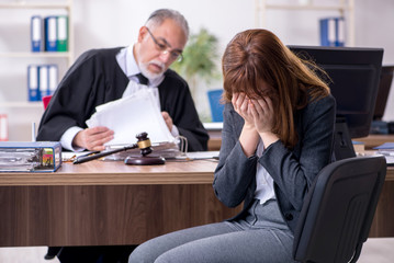 Old male judge and female client in the office