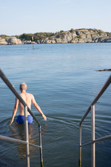 Man going for a swim in the swedish archipelago 