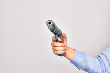 Hand of caucasian young woman holding gun over isolated white background