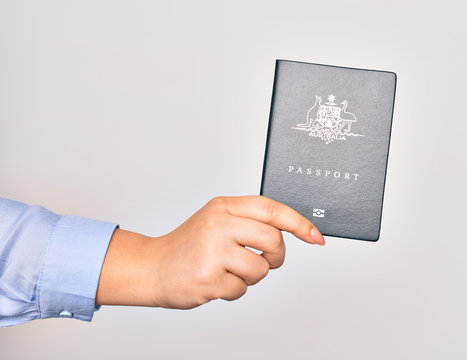 Hand of caucasian young woman holding Australia Australian passport document over isolated white background