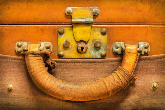 Close up of a vintage weathered brown leather suitcase
