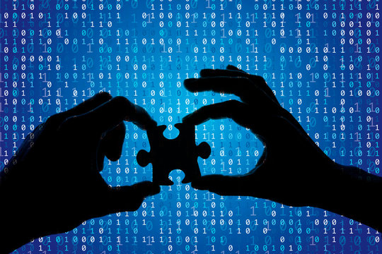 Silhouette of a hands holding a jigsaw puzzle piece with binary background