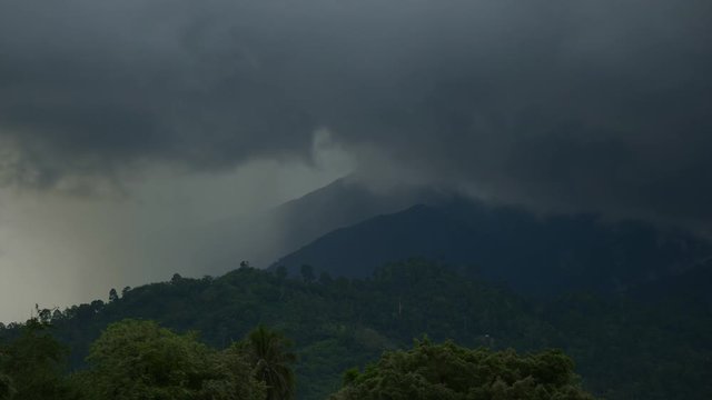 Dark Cloud Scudding Through Blue Sky with forest and tree blowing by Wind Before Rain Storm. Cloud Landscape At Sunset.