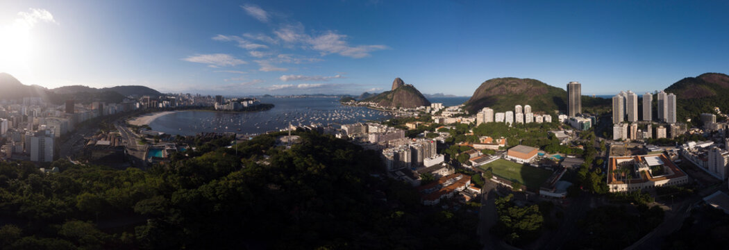 Rio de Janeiro wide panorama with Sugarloaf mountain and the wider cityscape of Guanabara bay and port for pleasure boats against a clear blue sky with the Pasmado hill park and lookout point in front