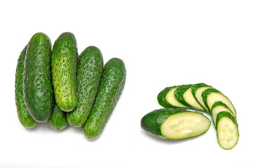 Six cucumbers on a white background. One chopped cucumber.