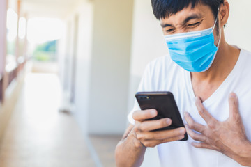 Man asian wear surgical mask hold smartphone search news covid 19 for stop covid 19 virus covid-19 or corona protected Help protect For social distancing world and people treatment method stop virus