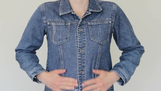 A Woman Adjusts A Denim Jacket.