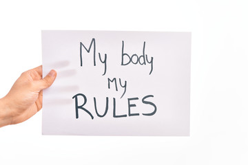 Cardboard banner with MY BODY MY RULES asking for body rights over isolated white background