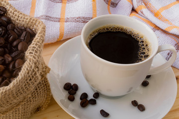 Cup of espresso with roasted coffee beans decorating the saucer
