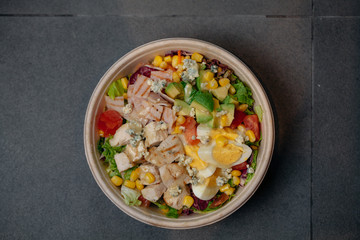 Keto salad with eggs, turkey ham, corn, tomato, blue cheese, avocado dressed with Italian dressing.