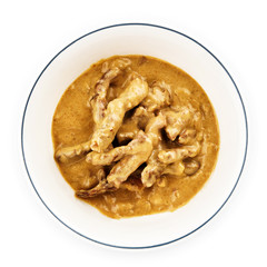 Sliced ​​beef in a sauce in a white plate.