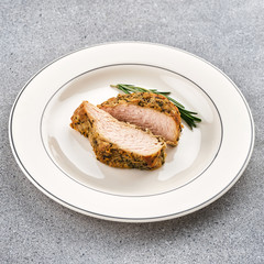 A piece of roast pork with rosemary.