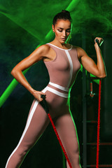Fototapeta na wymiar Fitness gym. Workout with bands or expander indoor. Individual sports recreation. Sporty and fit young woman athlete in sport outfit have a training. Concept of a healthy lifestyle and sport.