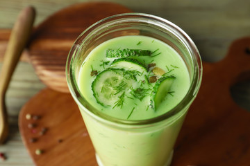 Glass with cold cucumber soup on table, closeup