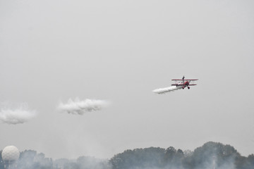 Red antique airplane flying during a grey day
