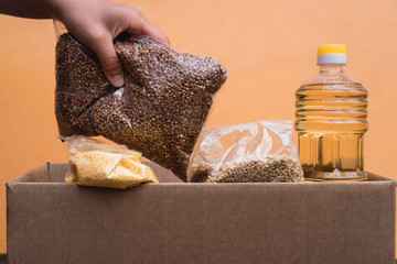 A box of food. Sunflower oil and various raw porridges. Buckwheat, Corn porridge, barley, rice.