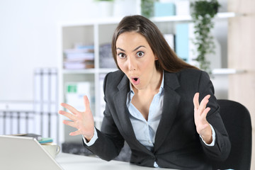 Amazed executive looking surprised at camera at office