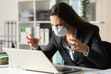 Angry executive looking at laptop avoiding covid-19 at office