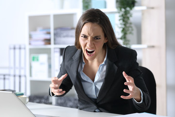 Angry executive looking camera sitting at office