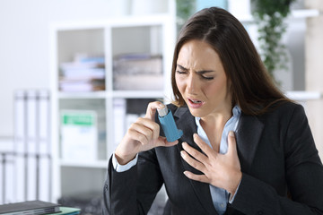 Executive holding inhaler with asthma attack at office - obrazy, fototapety, plakaty