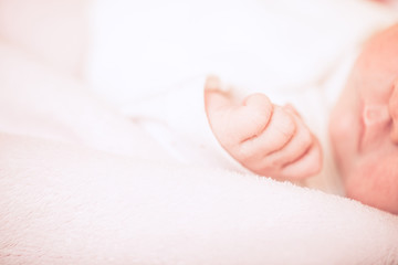 Adorable baby sleeping on stomach. Little hand of sleeping baby newborn close up.