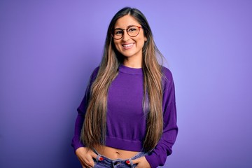 Young beautiful smart woman wearing glasses over purple isolated background with a happy and cool smile on face. Lucky person.